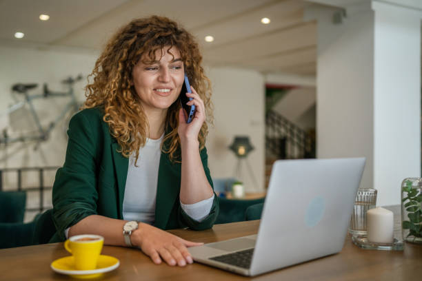istock Woman use smartphone make a call talk while work on laptop from cafe 1483619488