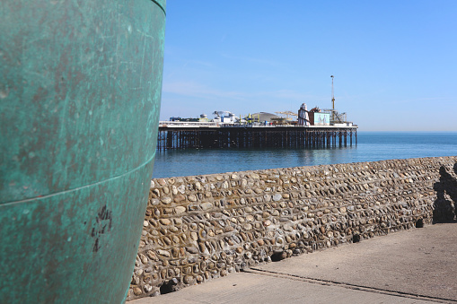 Brighton, United Kingdom - April 15, 2022: 'A public artwork by Hamish Black on Brighton seafront, UK. The sculpture is a circular donut shaped globe cast in bronze. Bronze sculpture on a groyne next to Brighton Palace Pier, Sussex, GB.