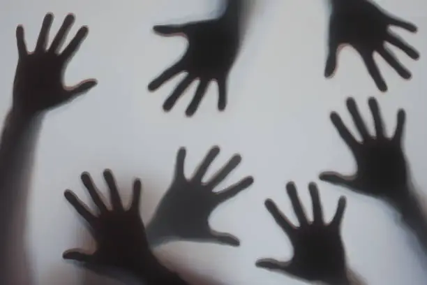 Photo of Human hands silhouette behind frosted glass