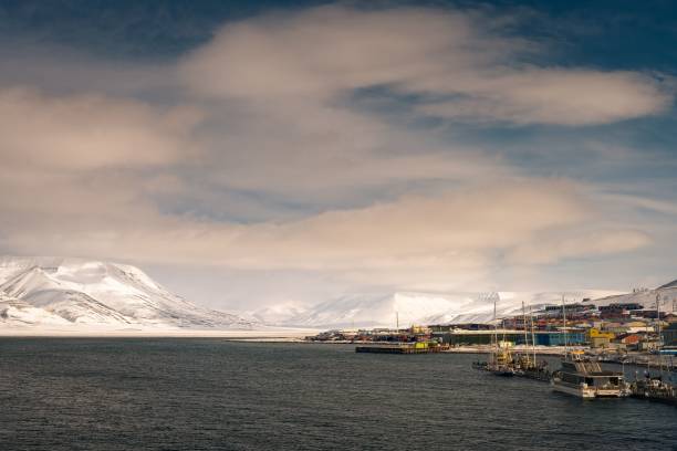 vista tranquila de la costa de longyearbyen, noruega con montañas nevadas como telón de fondo - harborage fotografías e imágenes de stock