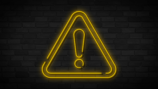 Yellow neon danger sign on brick wall. Elements of web set. Simple icon for websites, web design, mobile app, info graphics.
