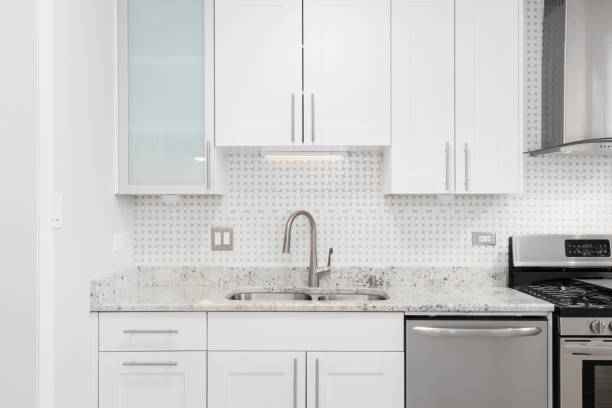 istock A kitchen sink detail with white cabinets and tiled backsplash. 1483631727