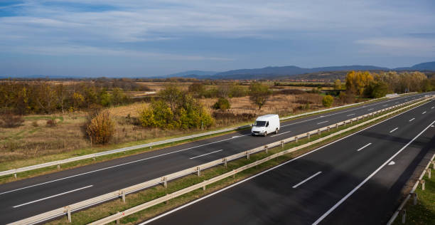 istock White delivery van on the highway. White modern delivery small shipment cargo courier van moving fast on motorway road to city urban suburb. The business distribution and logistics express service. 1483640859
