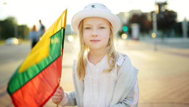 menina bonita que segura a bandeira lituana tricolor no dia do estado lituano - bandeira da lituânia - fotografias e filmes do acervo