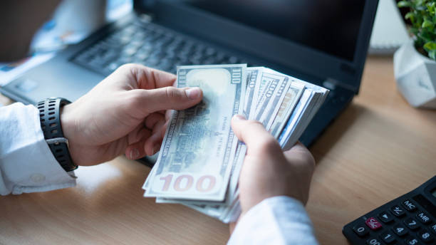 istock Businessman counting dollars at home office 1483644309