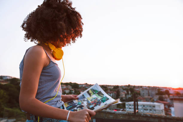 Girl on a rooftop Portrait of a teenage girl on a rooftop. Reading a comic. Enjoying the sunset. reading comic book stock pictures, royalty-free photos & images