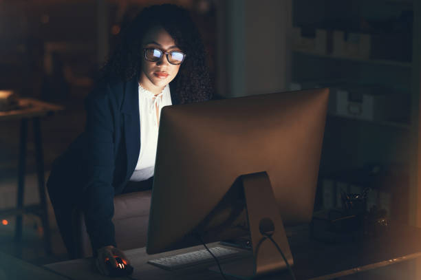 istock Business, night and black woman done on computer for project, strategy report and reading email. Corporate manager, dark office and female standing at desk working on schedule, planning and research 1483647516
