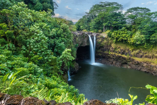 rainbow (waianuenue) falls es una cascada, hilo, hawái, estados unidos. el río wailuku se precipita en una gran piscina debajo. - hawaii islands big island waterfall nobody fotografías e imágenes de stock