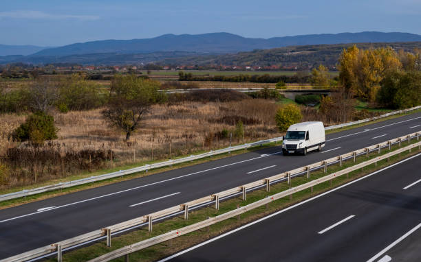 istock White delivery van on the highway. White modern delivery small shipment cargo courier van moving fast on motorway road to city urban suburb. The business distribution and logistics express service. 1483647836