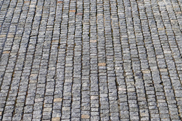 istock An old stoneblock pavement cobbled with granite blocks. Photo in perspective with selective focus 1483653186