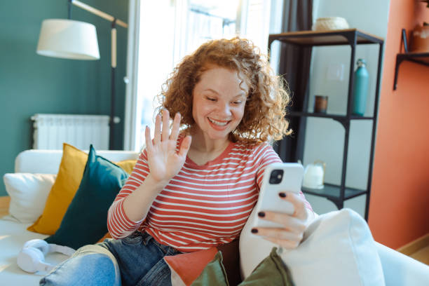 istock Beautiful redhead woman using smart phone for video call communication 1483655387