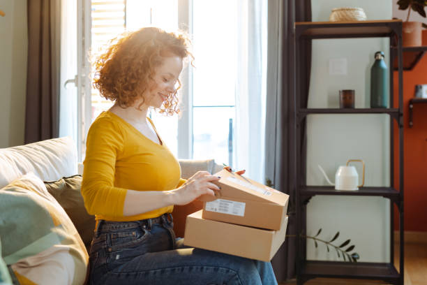 istock Smiling young woman unpacking cardboard box 1483657069