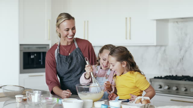 Children, cooking mix and home baking with mom learning to mix ingredients for fun and helping. Mother love, care and support by making food together with young kids and happiness in a house kitchen