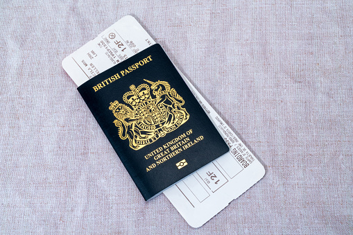 London, United Kingdom - March 7th, 2023 :   A new blue British passport with an airline boarding pass.  Since the United Kingdom has left the European Union in 2020, new British passports have returned to their original blue colour.
