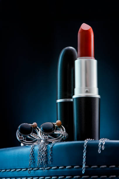 Studio shoot of Makeup, Lipsticks and Jewelry on the dark blue background