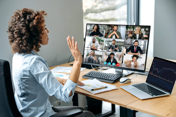 Confident successful businesswoman, company boss, stock investor, having financial brainstorm with group of multiracial people by video conference, discuss investments in the stock market, risks stock photo