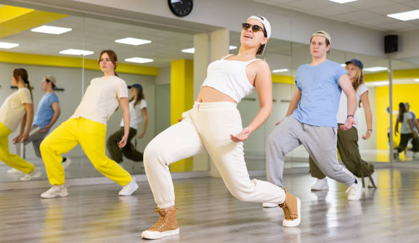 istock Group of cool, active teenage dancers having fun and learning new dance exercise movement in studio 1483674949