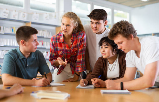 istock Group of schoolchildren in the school library, discussing something 1483675394