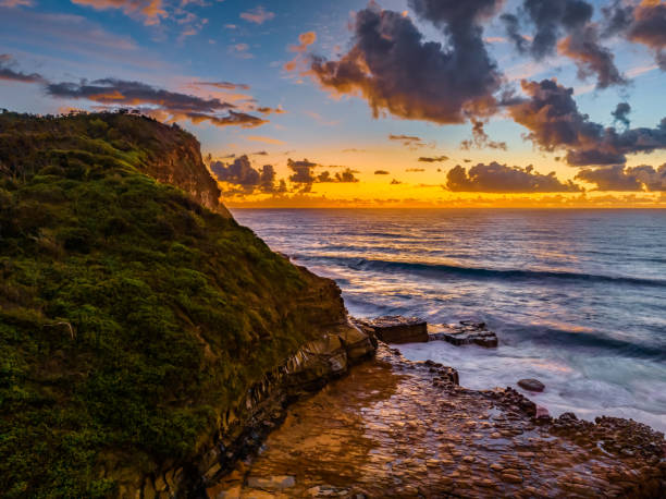 istock Sunrise and clouds over the ocean and rock platform 1483682630