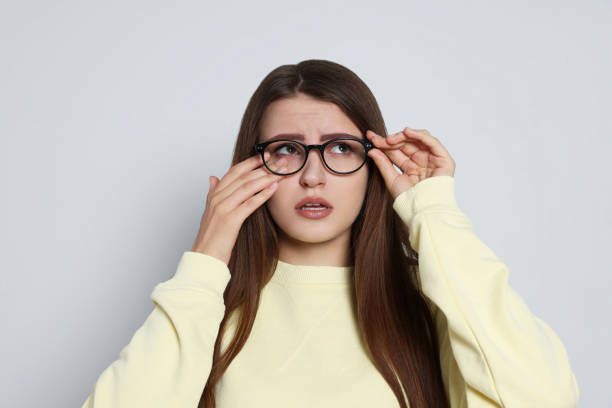 istock Young woman suffering from eyestrain on light background 1483686735