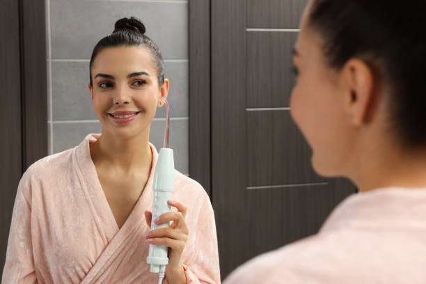 istock Woman using high frequency darsonval device near mirror in bathroom 1483686777