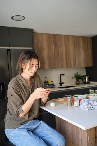 istock Asian young man checking recipe on mobile phone at kitchen. 1483687249