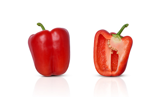 Whole and cut in half red bell pepper isolated cutout on white background