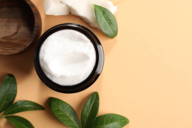 istock Flat lay composition with jar of coconut face cream on light orange background. Space for text 1483693989