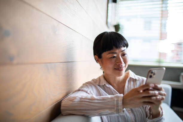 istock Young Asian woman using a smart phone at home 1483697375