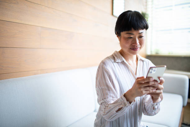 istock Young Asian woman using a smart phone at home 1483697457