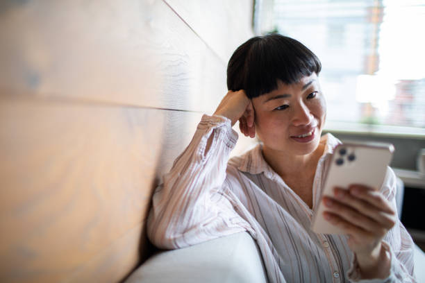 istock Young Asian woman using a smart phone at home 1483697481