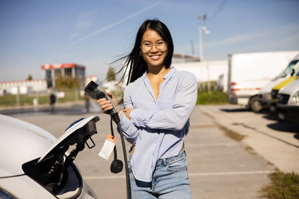 istock Asian young woman charging her electric van while traveling abroad 1483700580