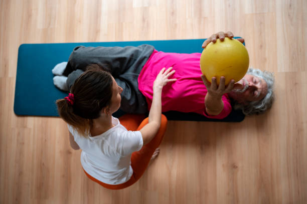 Physiotherapist working with a senior man helping him to rehabilitate and stay active stock photo