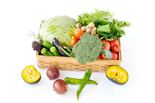Fresh, locally grown green and yellow vegetables that are pesticide-free or low in pesticides are heaped up in a basket.