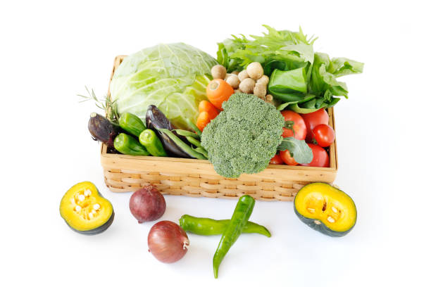 Fresh, locally grown green and yellow vegetables that are pesticide-free or low in pesticides are heaped up in a basket. stock photo