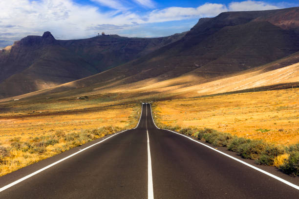 reisen auf den kanarischen inseln. beeindruckende landschaften des vulkanischen lanzarote. die malerische straße führt zum strand von famara - famara stock-fotos und bilder