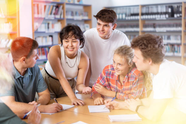 istock Group of schoolchildren in the school library, discussing something 1483708553