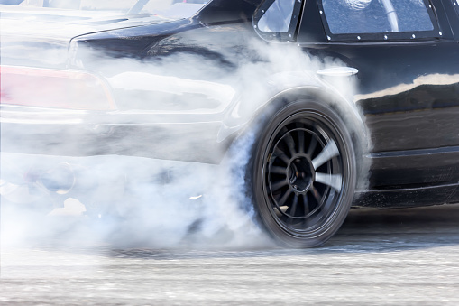 Race drift car burning tires on speed track