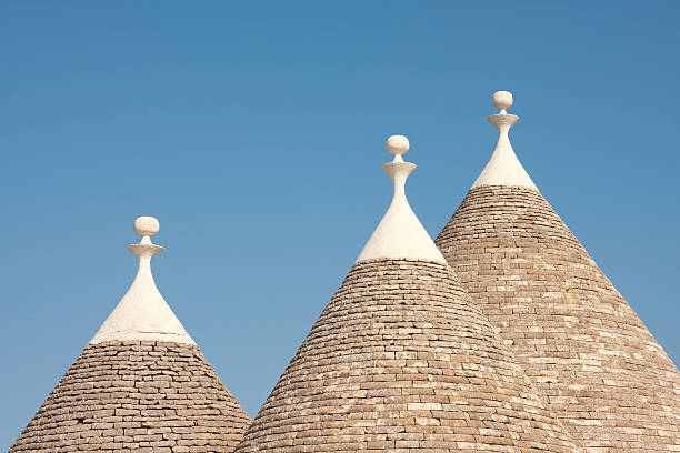 Traditional Trulli houses in Puglia, Italy Image of the cone shaped roof's of traditional Trulli houses in the Puglia region of Italy.  Image shot against the blue summer sky. trulli house stock pictures, royalty-free photos & images