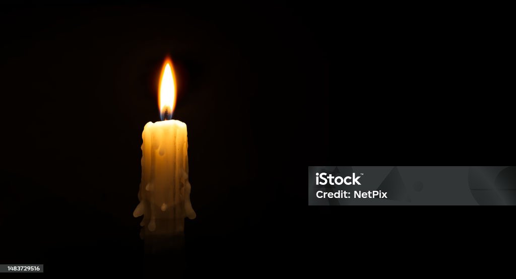 Burning wax candle against a black background Banner size image of burning candle against a black background with free copy space for text Backgrounds Stock Photo