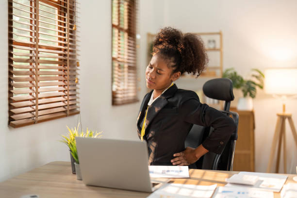 istock Young afro woman sitting suffering from back pain while working on laptop at office 1483732483