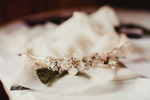 Arrangement of flower bunch, pearl necklace, gift box, bag, and lace glove on white cloth background, romantic concept, frame, copy space