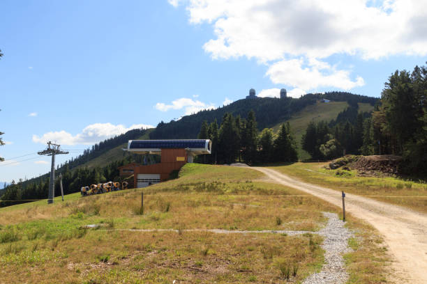 горнолыжный подъемник и снежные пушки на горе гроссер арбер с радиолокационными куполами (обтекателями) в баварском лесу, германия - radar dome mountain range mountain hill стоковые фото и изображения