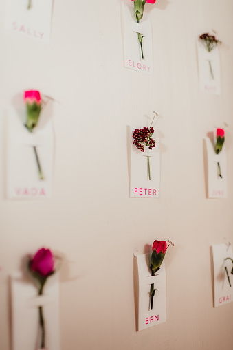 Flowers attached to name tags on a seating chart board