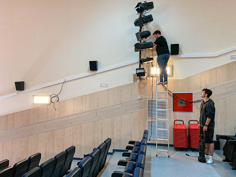 Sound technicians installing spotlights in a theater