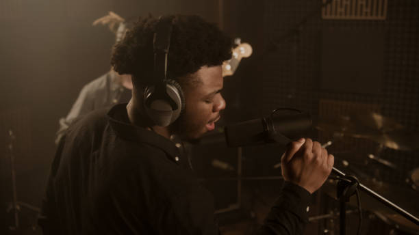 istock Vocalist in headphones records composition with band 1483762213