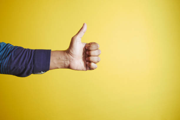 istock man hand showing a thumb-up on yellow background 1483762870
