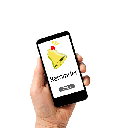 Close-up of hand holding black smartphone with reminder bell notification mockup and open button  on white background.