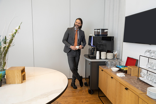 Businessman preparing coffee in the office , smiling