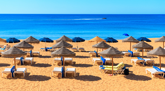 Summer holiday beach with sunbed and rood umbrellas- Portugal, Algarve